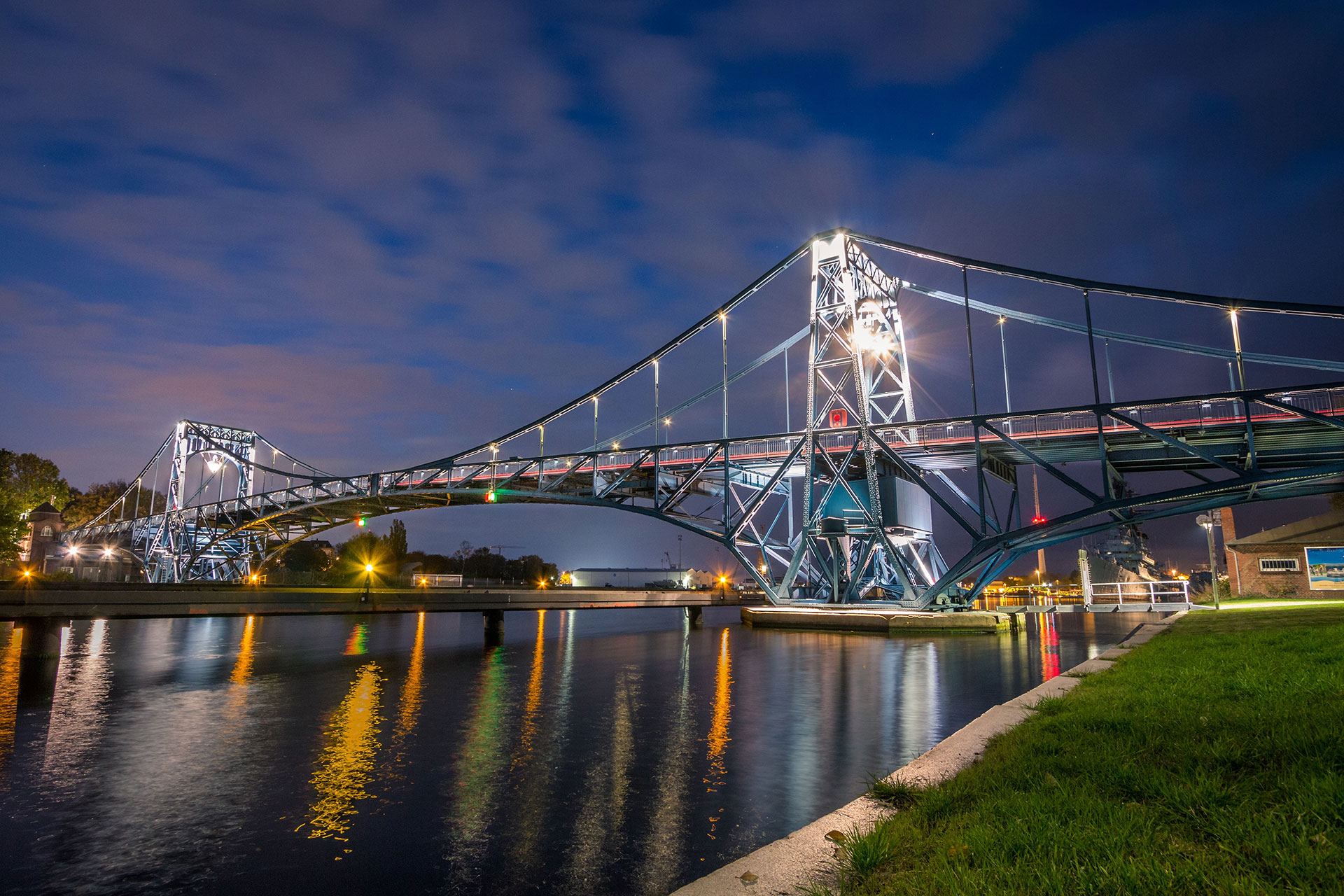 Das Bild zeigt die beleuchtete Kaiser-Wilhelm-Brücke bei Nacht.